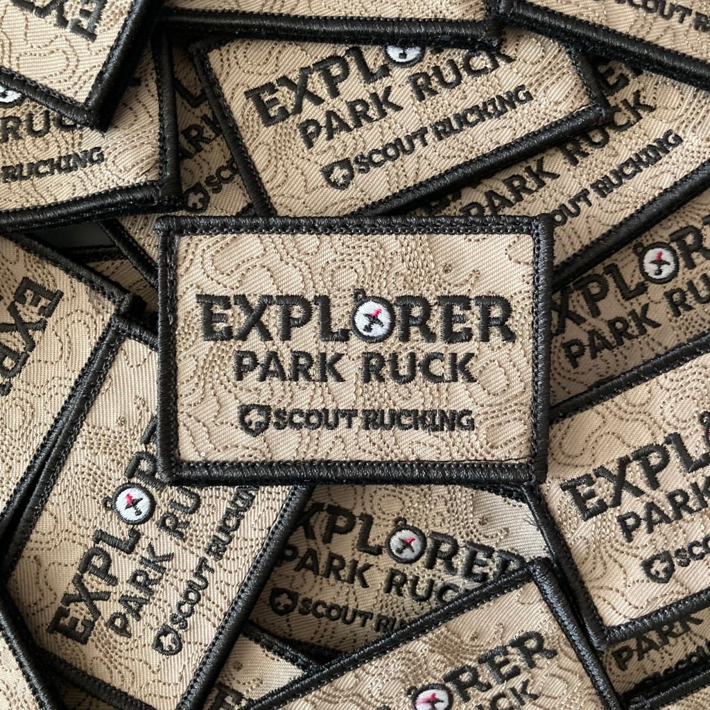 Pile of embroidered tactical patches with the Scout Rucking logo and the words, "Explorer: Park Ruck."
