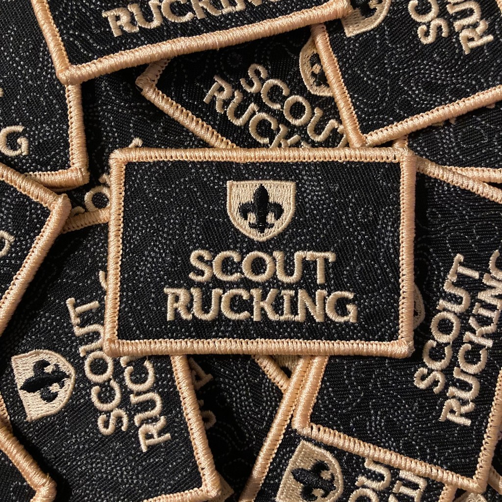 Pile of embroidered tactical patches with the Scout Rucking logo.