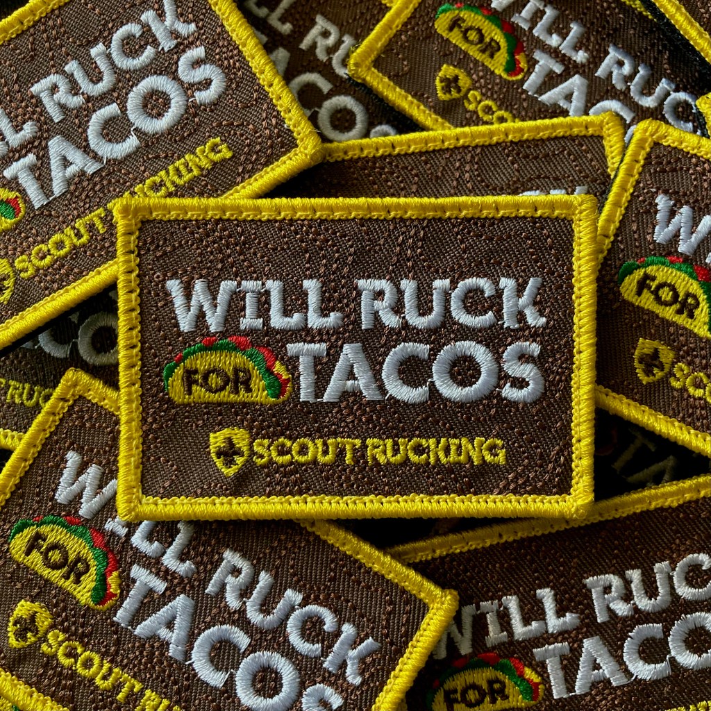 Pile of embroidered tactical patches with the Scout Rucking logo and the words, "Will Ruck for Tacos."